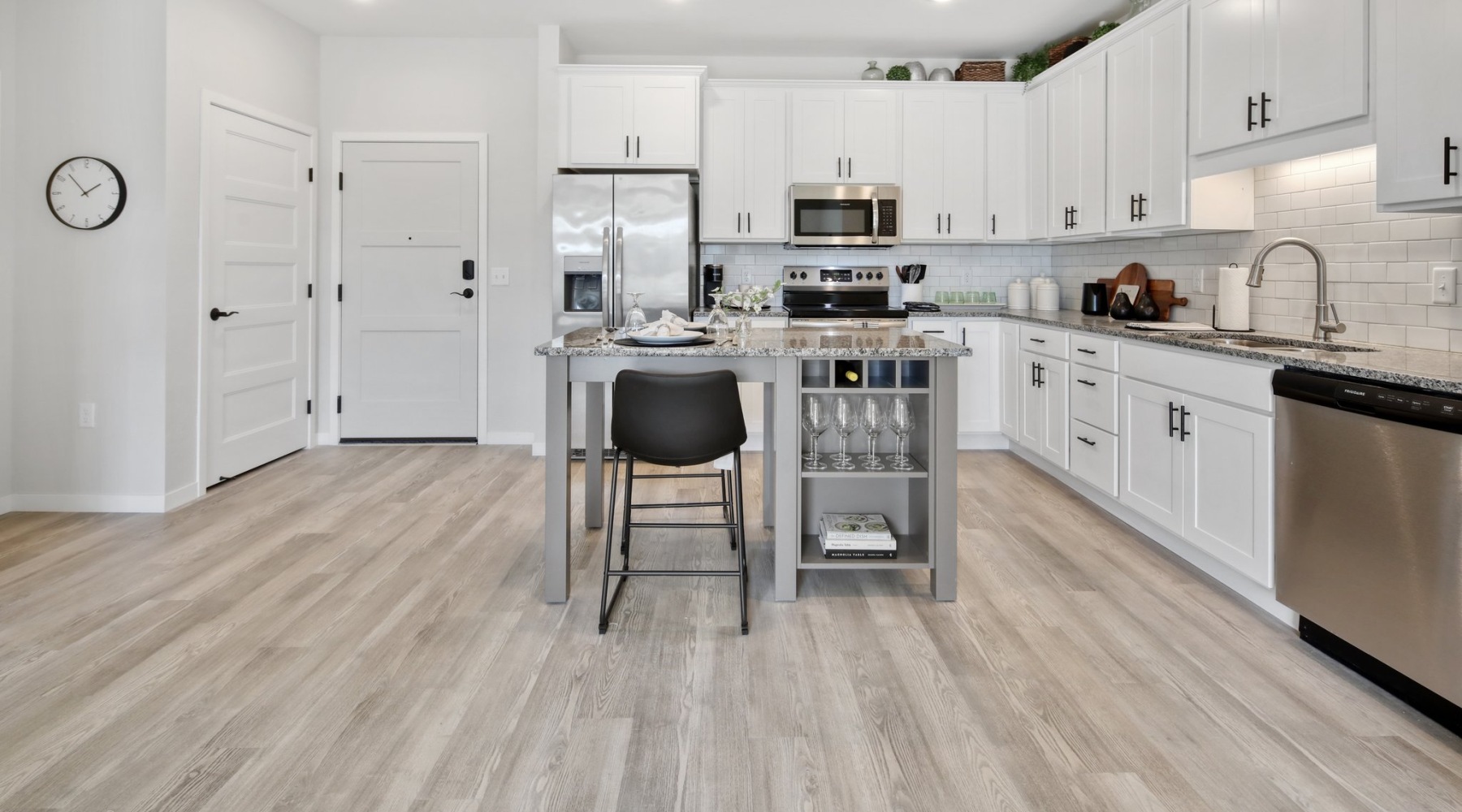 Well-lit kitchen with ample counter space Model kitchen at Arasan Apartments in Shakopee, MN, featuring stainless steel appliances and a kitchen island.