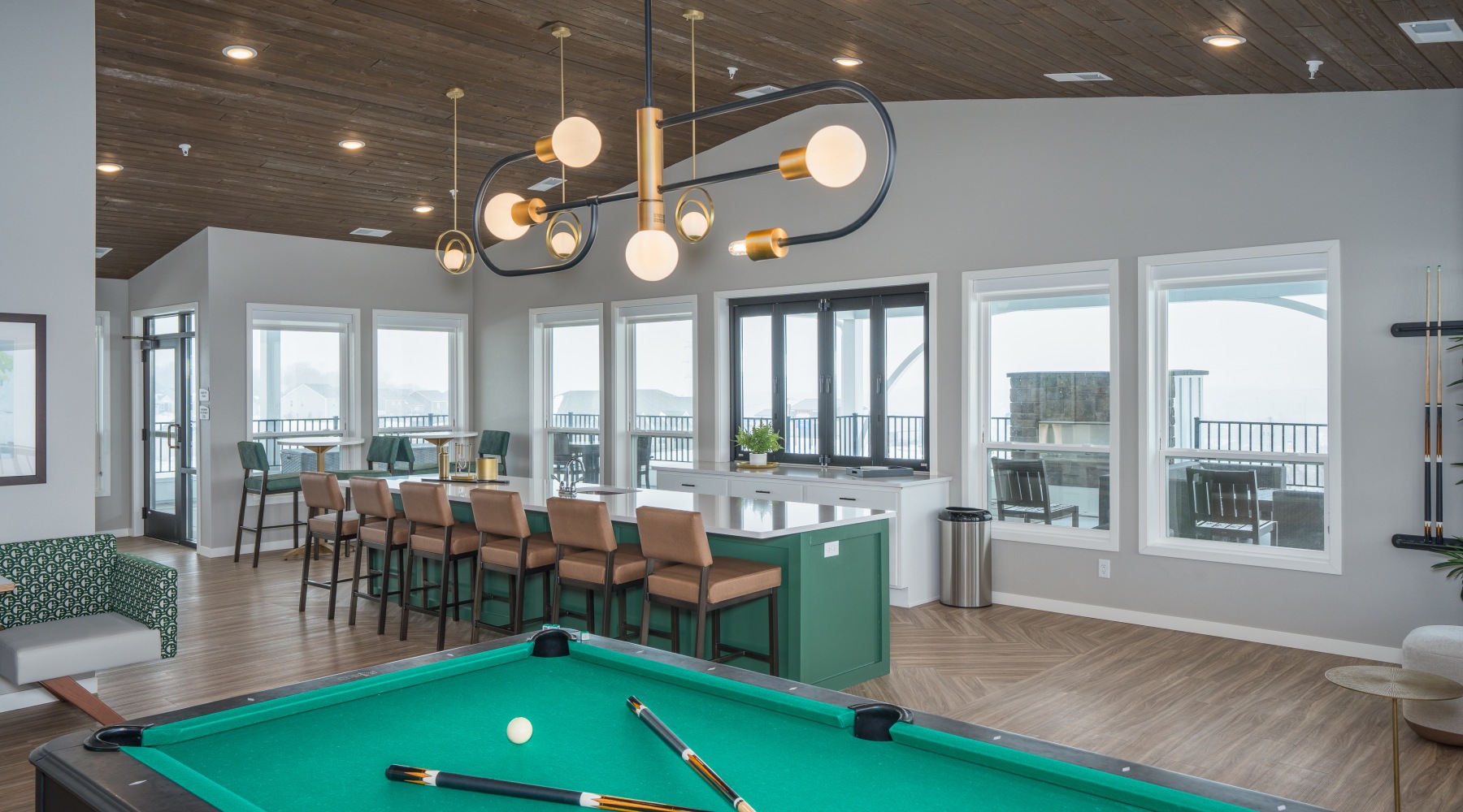 Community area with pool table.  Resident lounge at Arasan Apartments in Shakopee, MN, featuring a long table and floor to ceiling windows.